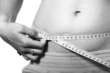 žena měřící si břicho po hubnutí